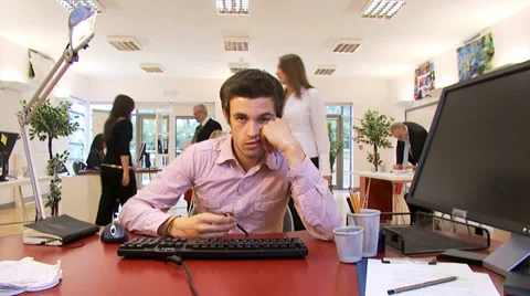 Bored male office worker struggles to stay awake at his desk. Stock Footage