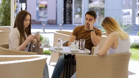 Bored man in caffe with two friends who are spending time on their phone Video stock 87392145