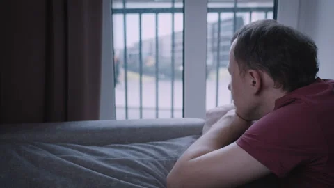 A bored man looks out of the window, watching the traffic outside, leaning on Stock Footage 314015853