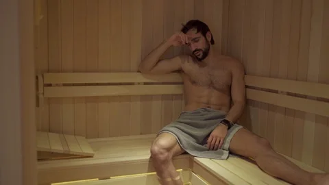Bored man resting and sweating in the spa sauna Stock Footage 127649053