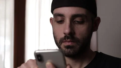 Bored man scrolling or browsing smartphone. Compulsive scrolling concept Stock Footage 168082964