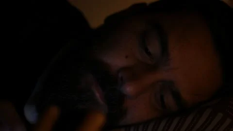 Bored man scrolling on smartphone application lying in bed. Stock Footage 164924825