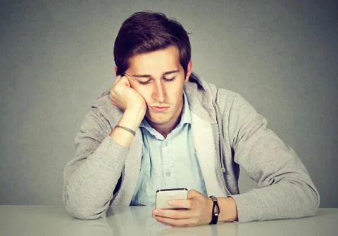 Bored man using his smart phone Stock Photos