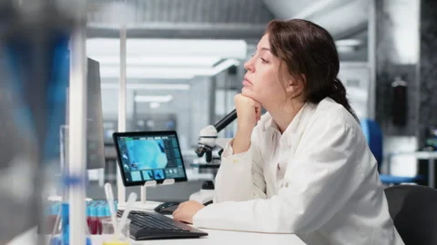 Bored medical laboratory technician using computer application Stock Footage 320722699