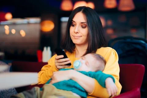Bored Mother Checking Smartphone While Baby is Sleeping Stock Photos