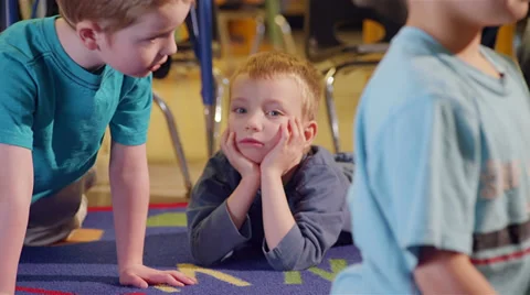 A bored preschool boy relaxes in class with his hands on his cheeks Stock Footage 34005094