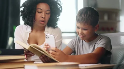 Bored school boy looking at smartphone ignoring mad mother because studying Stock Footage 248689985