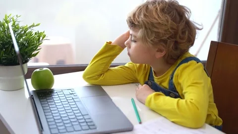 Bored Schoolboy child using laptop online educational lesson course at home Vidéo 235484536