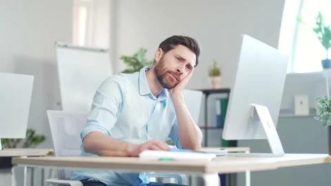 Bored sleepy office worker sitting at work workplace at computer desk leaning  Stock Footage 195188600