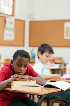 Bored student leaning on a stack of books Foto stock