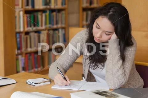 Bored student in a library learning Stock Photos