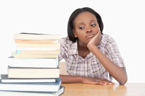 Bored student looking at a stack of books Stock Photos