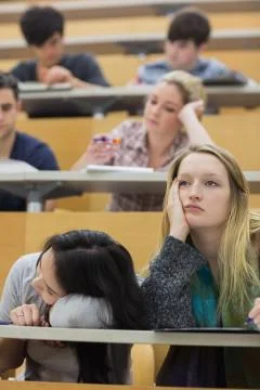 Bored students sitting in a lecture hall Stock Photos