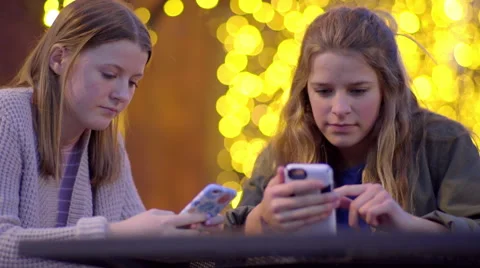 Bored Teens Wait For Food To Arrive, They Play On Their Smartphones Stock-Footage 61805565