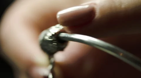 Bored Woman Playing With Lucky Charms On A Silver Bracelet Stock Footage 59559713