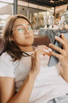 Bored woman using smartphone boringly in the cafe. Foto stock