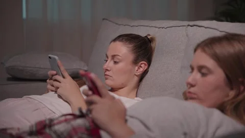 Bored women lying on sofa using mobile phone Stock Footage 241227244