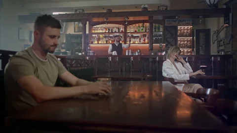 A boring bar where a man and a woman are sitting, Vídeos de archivo 158103055