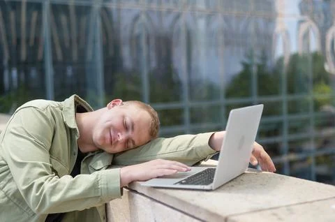 Boring man with hearing aid using laptop outdoors. Stock-Fotos