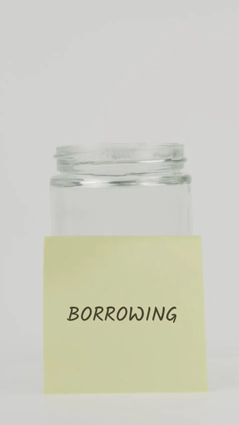 Borrowing text or word on yellow sticky note attached to glass jar with hand Stock Footage 311683688