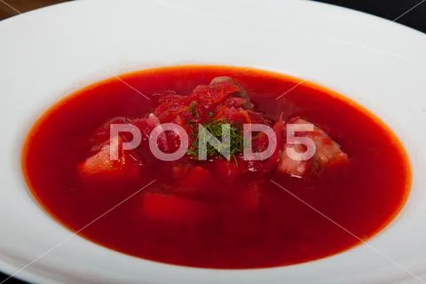 Borsch - a soup of beets in an earthenware bowl on a cipher, a stone or metal Stock Photos