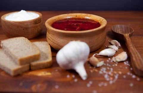 Borscht red soup with rye bread and garlic on a dark background. Borscht with Stock Photos