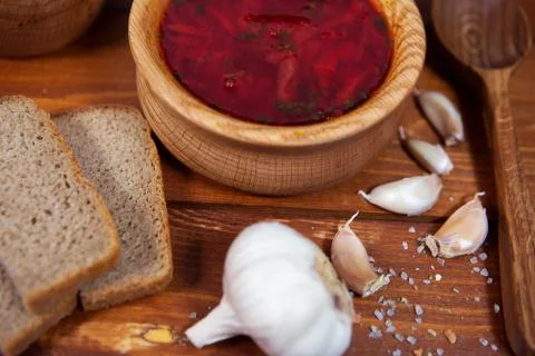 Borscht red soup with rye bread and garlic on a dark background. Borscht with Stock Photos