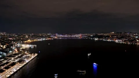 Bosphorus bridge illuminates night sky over Istanbul bustling waterway view. Video stock 344242159
