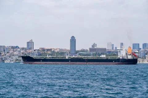 Bosphorus waterway with cargo ship navigating through urban landscape under Stock Photos