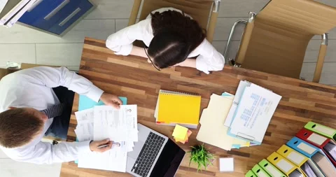 Boss and applicant sit at desk with papers during job interview Stock Footage 312147345