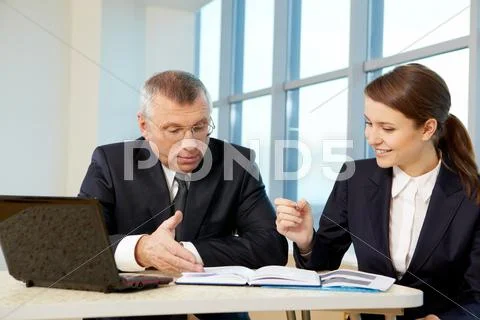 Boss and secretary planning work in office Stock Photos