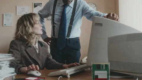 Boss Checking on Apprentice Working on Outdated Computer in 90s Office Stock Footage 280262498