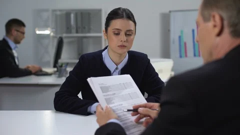 Boss checking data in annual report, asking female manager to correct mistake Stock Footage 112097589