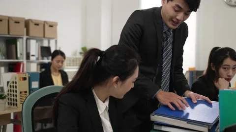 Boss giving a heavy stack of documents to worker Stock Footage 179565885