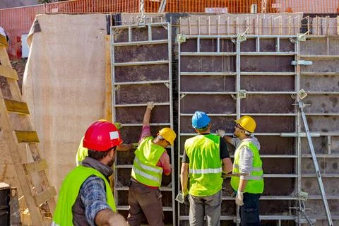 Boss oversees, control riggers, workers as assembly wooden demountable mold Stock Photos