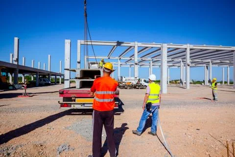 Boss oversees, control unloading concrete joist in truck trailer Stock Photos