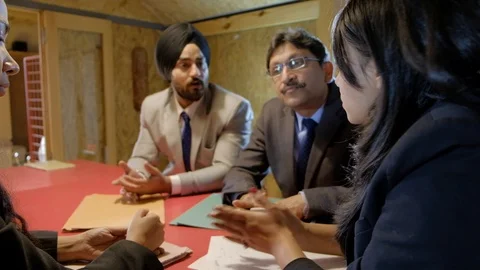 Boss takes notes on paper with pen as they discuss work and explain Stock Footage 102322302