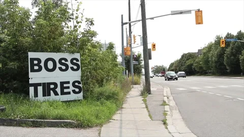 Boss tires writing caption text square sign on grass with sidewalk traffic light Stock-Footage 249102541