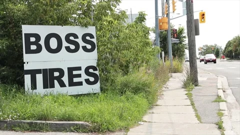 Boss tires writing caption text square sign on grass with sidewalk traffic light Stock Footage 249102595