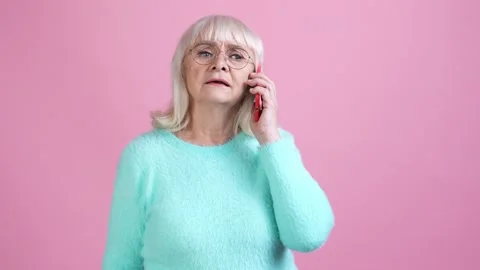 Bossy old lady answer gadget call irritated isolated pastel color background Video stock 169289631