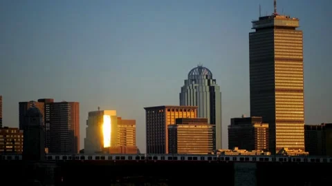 Bostons skyline glows at sunset, reflecting golden light on buildings Stock Footage 312679156