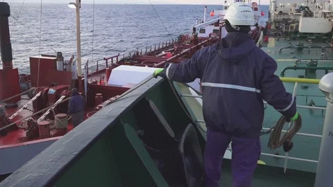 Bosun throws mooring rope to client ship from oil tanker Stock Footage 121117208
