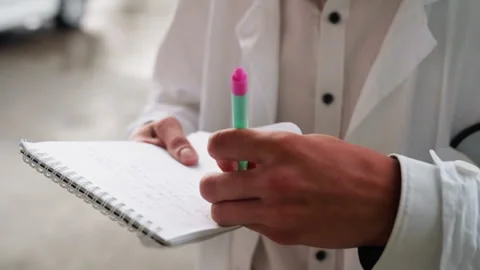 Botany Student in White Coat Writing Notes in Jotter Stock Footage 321115052
