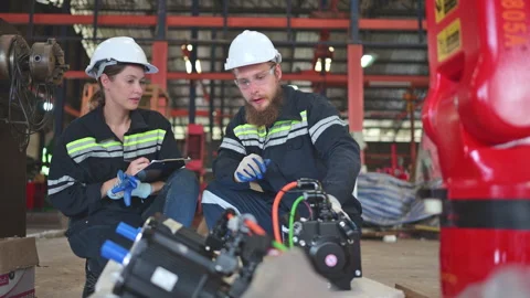 Both of engineers installing a small robotic arm is being installed for testing Stock Footage 254544721
