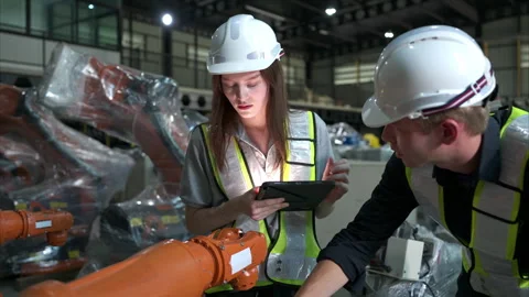 Both of engineers working together in a robotic arm factory Stock Footage 262753457