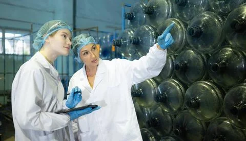Both of female quality control workers in a drinking water factory Inspect... Stock Photos