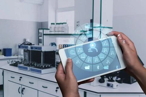 Both Hands Holding A Mobile Phone In Laboratory Showing Futuristic Technolo.. Stock Photos