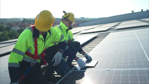 Both of technicians is installing solar panels on the roof of the warehouse Stock Footage 260158566