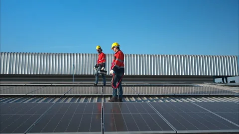 Both of technicians is installing solar panels on the roof of the warehouse Stock Footage 260238509
