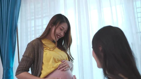 Both of young expecting mother holding baby in pregnant belly. Stock Footage 260676067